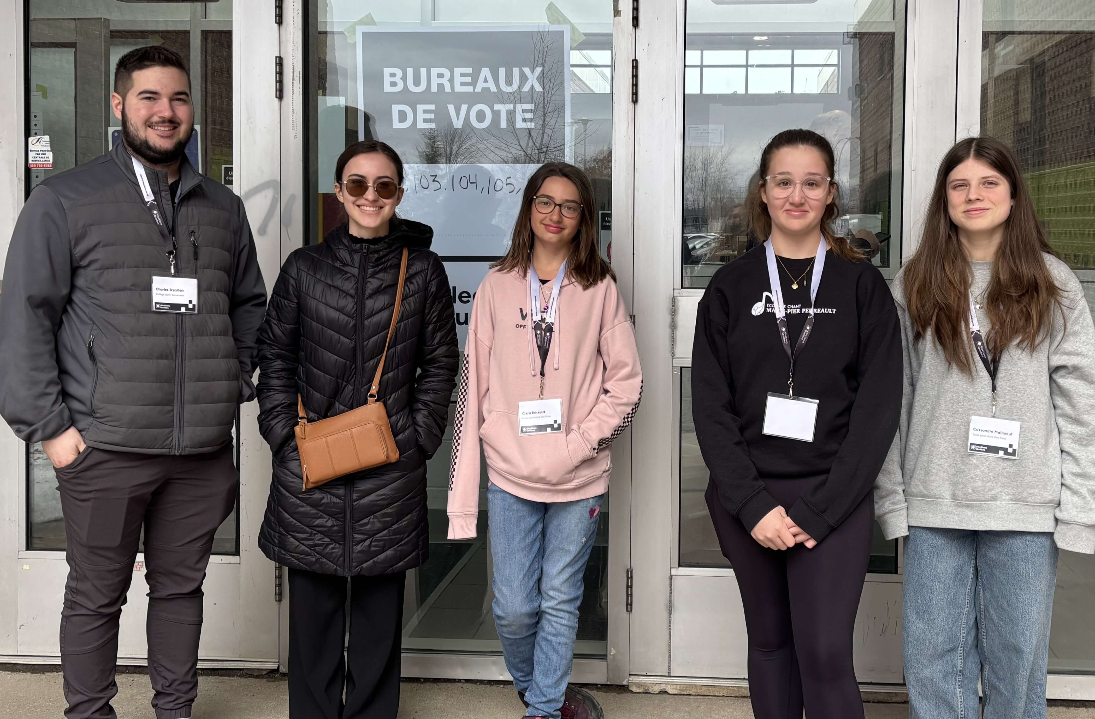 Cinq jeunes devant les portes d’un bureau de vote.